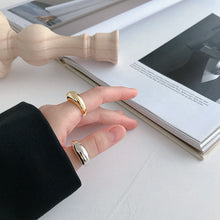 Cargar imagen en el visor de la galería, En la imagen una mano con dos anillos de plata y oro posando con una revista
